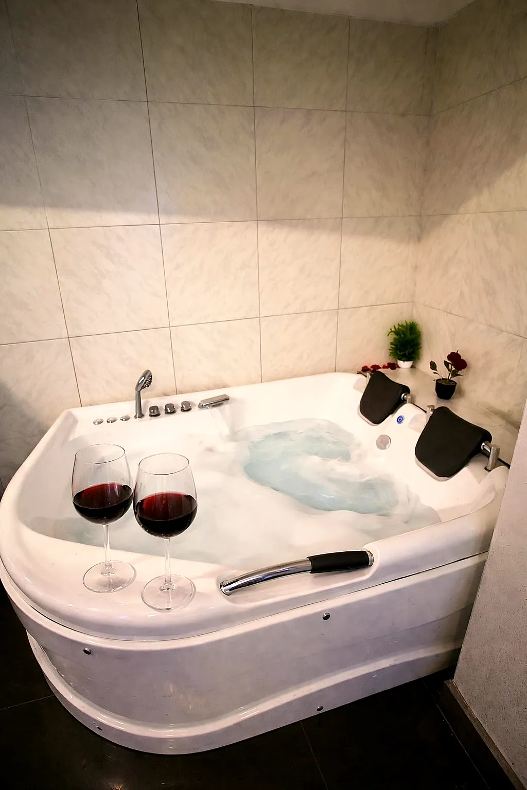 Jacuzzi privado con copas de vino en Qoeurs Spa
